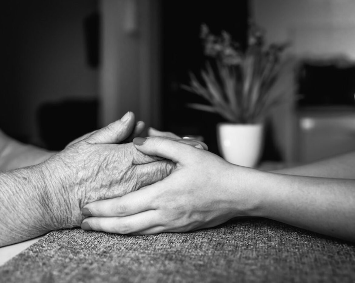 Old and young female hands are holding, elderly care and respect, close-up.